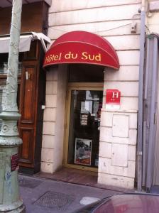 uma loja com um toldo vermelho num edifício em Hôtel du Sud Vieux Port em Marselha