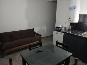 a living room with a couch and a table at Hospedaje "Crisbel" en Las Catitas in Las Catitas +2 photos