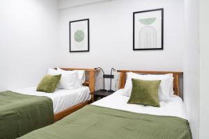 two beds in a room with green and white at Knox Hatyai just 10 steps to Greenway Night Market in Sathani Khlong Rian