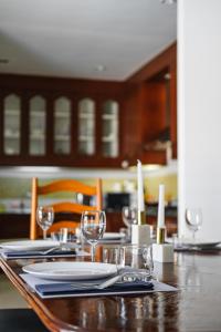 a dining table with plates and wine glasses on it at Luxury Massarossa Pool Villa Pattaya-21 in Pattaya Central