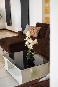 a living room with a couch and a table with flowers on it at Luxury Massarossa Pool Villa Pattaya-21 in Pattaya Central