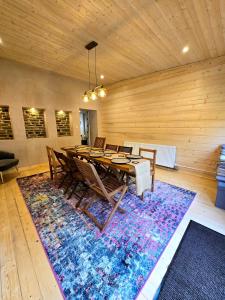 a dining room with a table and chairs on a rug at Ash Cottage in Hope