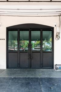 a black door with windows on a building at Knox Hatyai just 10 steps to Greenway Night Market in Sathani Khlong Rian