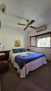 ein Schlafzimmer mit einem Bett mit Deckenventilator in der Unterkunft Hotel Riviera in Villa Gesell + 49 Fotos