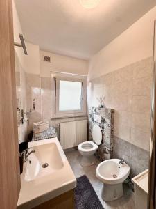 a white bathroom with a sink and a toilet at Lake Apartment Ischia White, Lago di Caldonazzo in Tenna  +30 photos