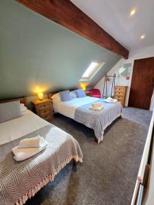 una camera da letto con due letti con asciugamani sopra di Birch Cottage a Hope Altre 23 foto