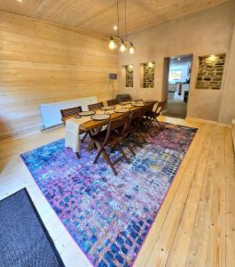 una grande sala da pranzo con un lungo tavolo su un grande tappeto di Birch Cottage a Hope