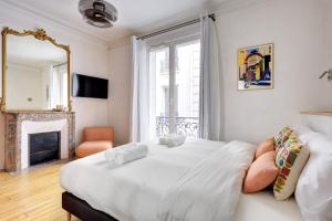 巴黎Prestige Marais的卧室里有一张白色的大床和一个壁炉