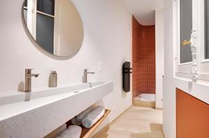 巴黎Prestige Marais的浴室里有两个洗手池和一面镜子