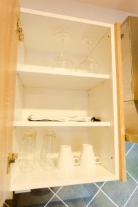 a cupboard filled with glasses and wine glasses at Accra Luxury Apartments at Oasis Park in Accra