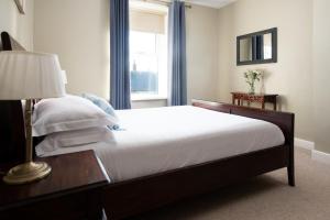 a bedroom with a bed with a lamp and a window at Driftwood Cottage by Coast & Country Stays in Seahouses +26 photos