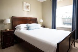 a bedroom with a large bed and a window at Driftwood Cottage by Coast & Country Stays in Seahouses