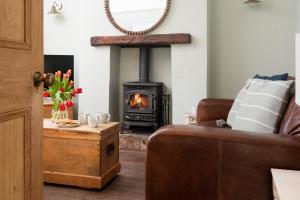 a living room with a wood stove in the corner at Driftwood Cottage by Coast & Country Stays in Seahouses