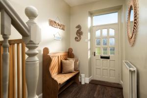 a hallway with a wooden bench next to a door at Driftwood Cottage by Coast & Country Stays in Seahouses