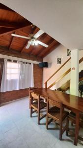 a dining room with a wooden table and stairs at Cabañas Brochero del Valle in Villa Cura Brochero