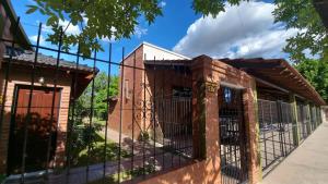 a fence in front of a building at Cabañas Brochero del Valle in Villa Cura Brochero +13 photos