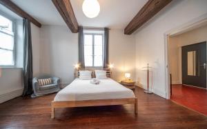 a bedroom with a large bed in a room with wood floors at L'appartement Cosy in Tournus