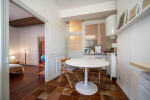 a kitchen and dining room with a white table and chairs at L'appartement Cosy in Tournus