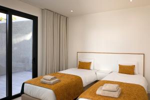 a bedroom with two beds with towels on them at Marco 4 Seasons- Spring in Arco da Calheta +14 photos