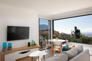 a living room with a couch and a table at Marco 4 Seasons- Spring in Arco da Calheta