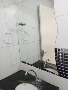 ein Badezimmer mit Waschbecken und Spiegel in der Unterkunft Espaço Vila Verde in Paulista