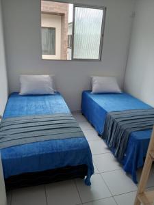 zwei Betten in einem Zimmer mit Spiegel in der Unterkunft Espaço Vila Verde in Paulista