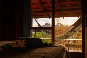 a bedroom with a bed and a hammock in a window at Pousada Porto Belo in Porto Belo +23 photos