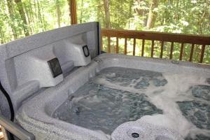 a jacuzzi tub with snow on a deck at Jack Pine Hollow in Logan +25 photos