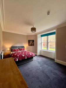 a bedroom with a red bed and a window at The Farmhouse Snug in Spean Bridge