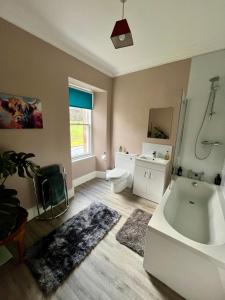 a bathroom with a tub and a sink and a toilet at The Farmhouse Snug in Spean Bridge +33 photos