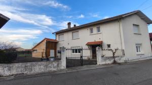 a white house on the side of a street at Maison familiale in Orleix