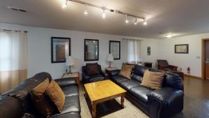 a living room with leather couches and a coffee table at Moonbeam Chalet in Logan +28 photos