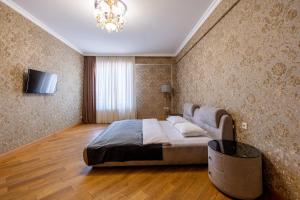 Un dormitorio con una cama y un televisor en una pared. en Luxury accommodation, en Tiflis 42 fotos más