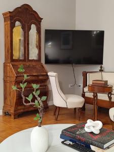 a living room with a tv and a chair and a table at HouSmart Lorenzo Costa 17 in Bologna