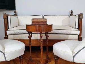 a couch and two chairs and a table with a stool at HouSmart Lorenzo Costa 17 in Bologna