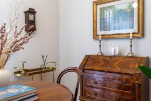 a dining room with a table and a wooden dresser at HouSmart Lorenzo Costa 17 in Bologna