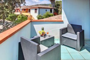 波尔托奥蒂罗卢ISA-Residence with swimming-pool in Ottiolu just 250 mt from the sea, apartments with air conditioning and private outdoor area的阳台上配有桌椅的露台