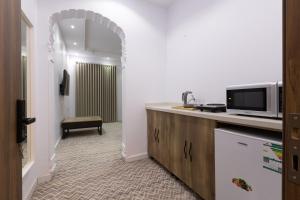 a room with a tv and a counter with a microwave at Al-Jamwaut B in Medina