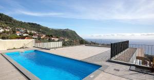 a swimming pool on a patio with a view of the ocean at Marco 4 Seasons- Spring in Arco da Calheta