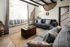 a living room with a couch and a window at Harbour Way Cottage by Coast & Country Stays in Seahouses