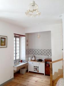 un bagno bianco con lavandino e lampadario pendente di Maison d'Orion a La Réole