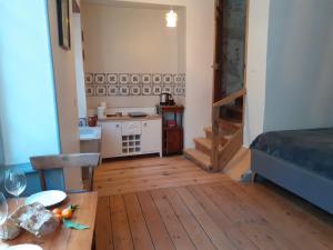 a living room with a table and a room with a bed at Maison d'Orion in La Réole