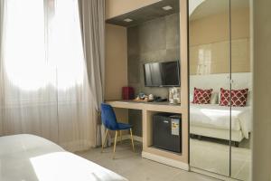 a bedroom with a bed and a desk with a tv at Corso Boutique Luxury Rooms in Rome