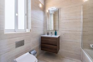 a bathroom with a sink and a toilet and a tub at Bright and modern apartment in St Julian's