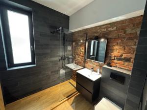 a bathroom with a sink and a brick wall at Zen Retreat Apartment in Sinaia +25 photos