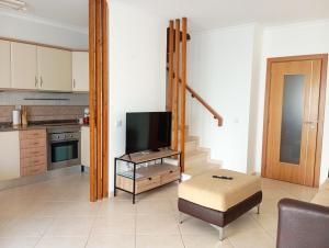 sala de estar con TV y cocina en Villa Cacela Mar, en Vila Nova de Cacela