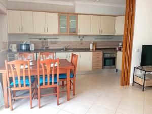 Una cocina con una mesa de comedor y sillas de madera. en Villa Cacela Mar, en Vila Nova de Cacela