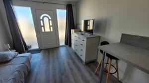a bedroom with a bed and a dresser with a mirror at Studio NEUF et élégant avec CLIM in Tarbes