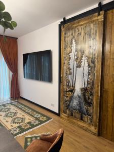 a living room with a large painting on the wall at Zen Retreat Apartment in Sinaia