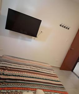 a flat screen tv on the wall of a bedroom at Flat Térreo em Meio a Natureza in Camaragibe